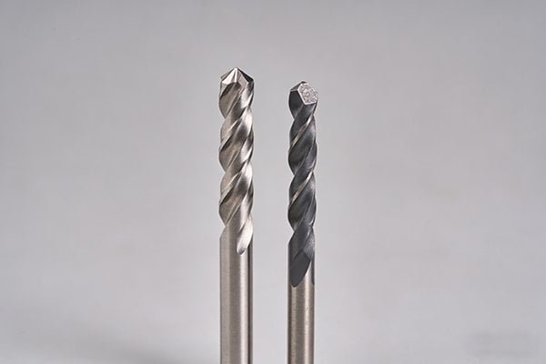 A carbide drill bit next to a solid carbide end mill